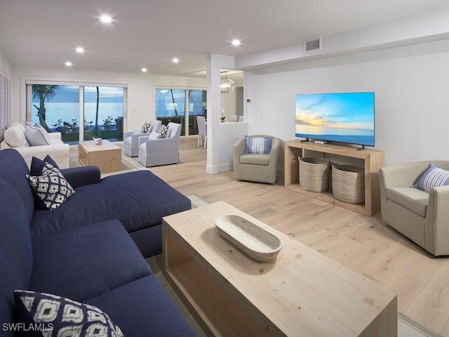 living room with an inviting chandelier and light hardwood / wood-style flooring