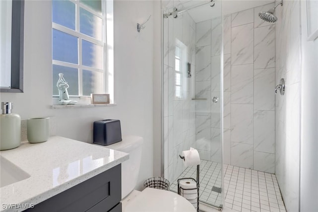 bathroom featuring a healthy amount of sunlight, vanity, toilet, and a shower with shower door