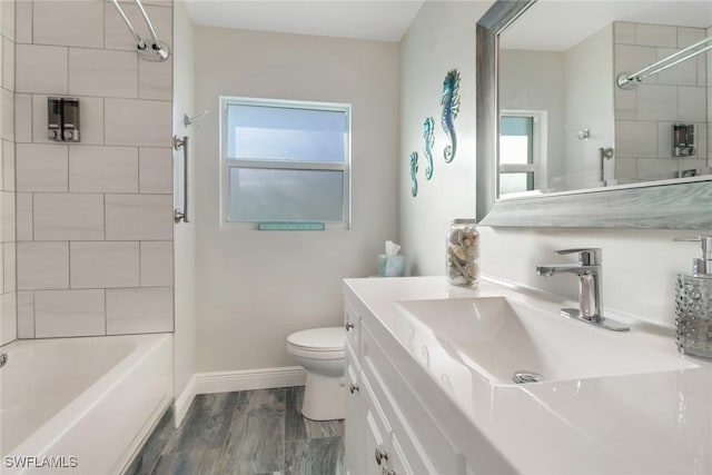 full bathroom with vanity, tiled shower / bath combo, toilet, and hardwood / wood-style flooring