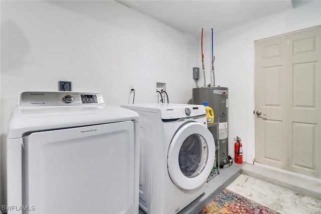 washroom with washer and clothes dryer and water heater