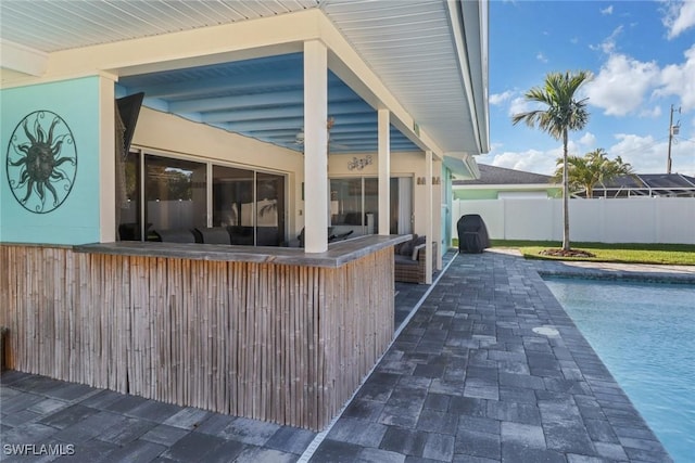 view of patio with a bar and a fenced in pool