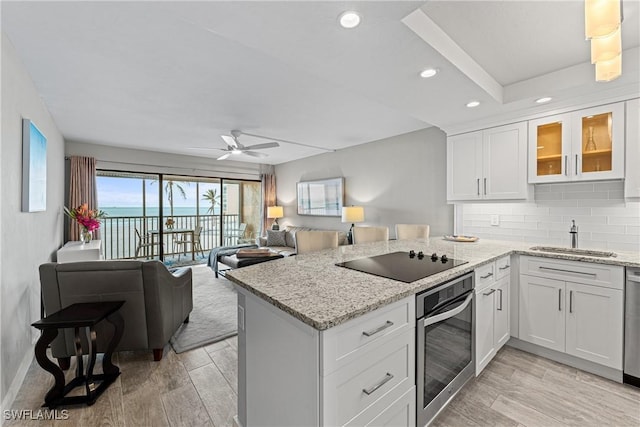 kitchen featuring ceiling fan, appliances with stainless steel finishes, white cabinets, and sink