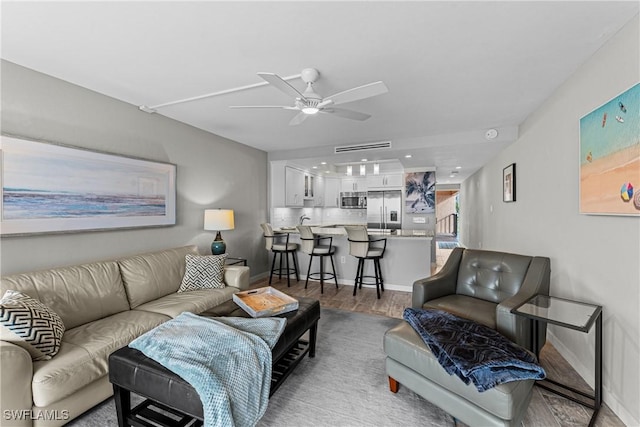 living room with ceiling fan and wood-type flooring