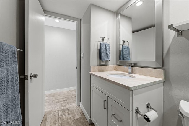 25850 Hickory Blvd Unit A-104, Bonita Springs, FL 34134 - bathroom featuring vanity, toilet, and wood finished floors