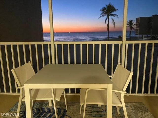 balcony at dusk with a view of the beach and a water view