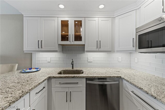 25850 Hickory Blvd Unit A-104, Bonita Springs, FL 34134 - kitchen featuring appliances with stainless steel finishes, a sink, white cabinetry, glass insert cabinets, and recessed lighting