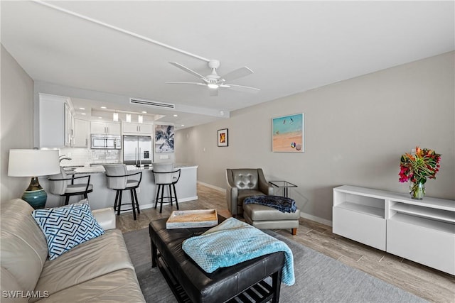 living room featuring ceiling fan and light hardwood / wood-style floors