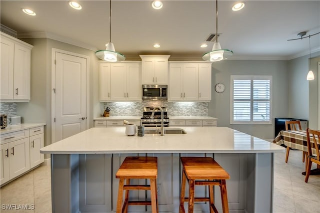 kitchen with sink, hanging light fixtures, a center island with sink, and stainless steel appliances