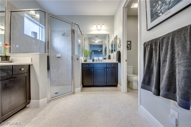 bathroom featuring toilet, vanity, tile patterned floors, and a shower with shower door