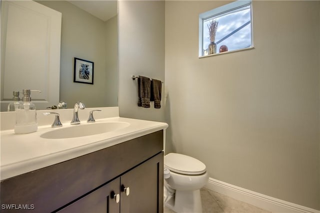 bathroom featuring toilet, vanity, and tile patterned flooring