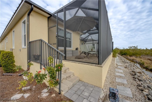 view of home's exterior with a patio area and a lanai