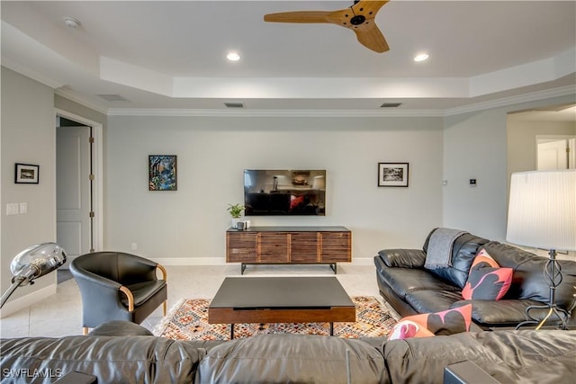 living room with ceiling fan, a tray ceiling, and crown molding