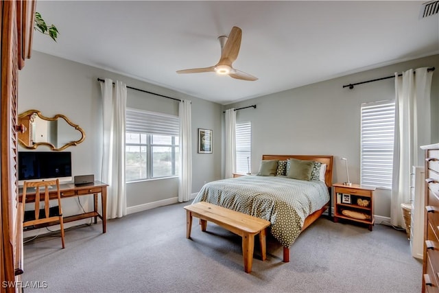 carpeted bedroom with ceiling fan and multiple windows