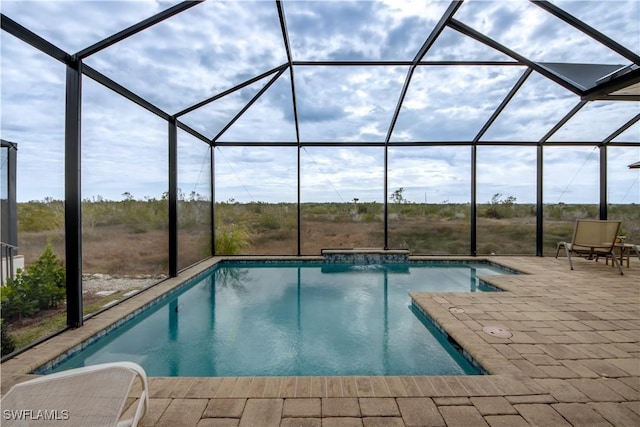 view of swimming pool with a patio and glass enclosure