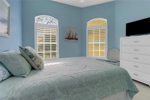 bedroom featuring light tile patterned floors and multiple windows