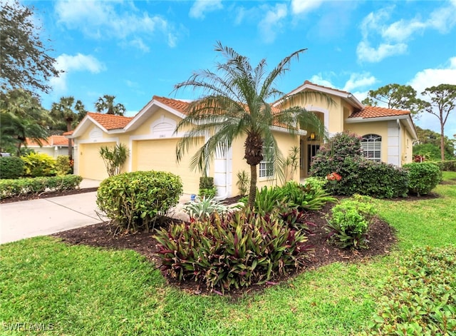 mediterranean / spanish-style home with a garage and a front lawn