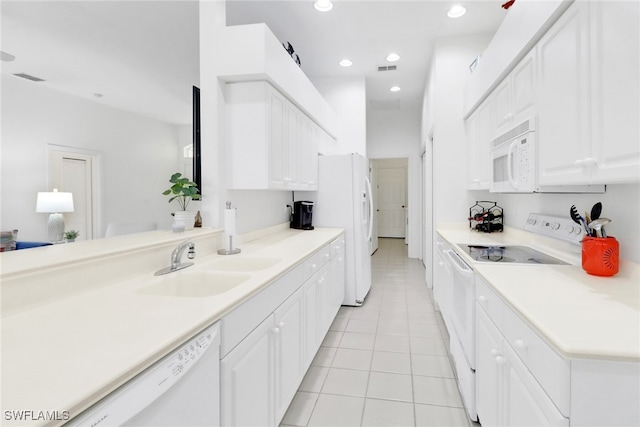 kitchen featuring light tile patterned floors, white cabinetry, sink, and white appliances