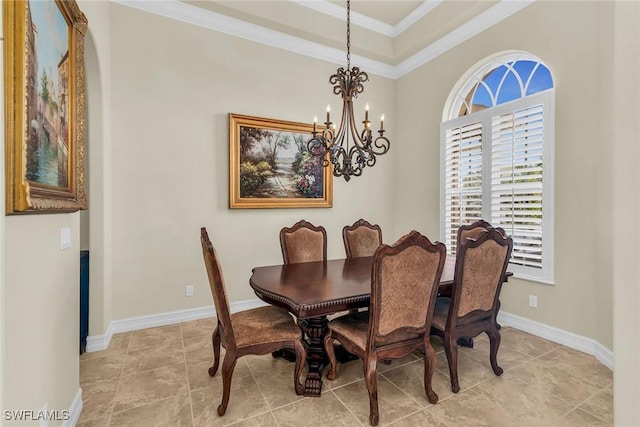 dining space featuring a chandelier, a raised ceiling, and ornamental molding