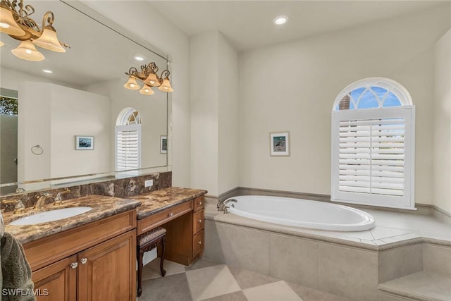 bathroom featuring vanity, a healthy amount of sunlight, and tiled bath