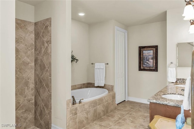 bathroom featuring vanity, tiled tub, and tile patterned flooring