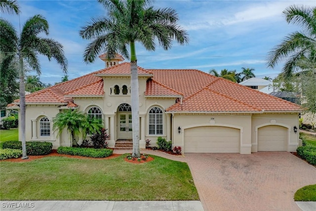 mediterranean / spanish-style house with a garage and a front lawn