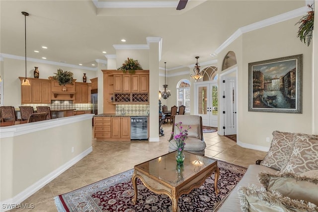 living room featuring french doors, an inviting chandelier, wine cooler, light tile patterned flooring, and crown molding