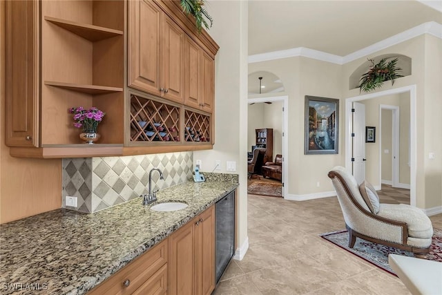 kitchen with crown molding, sink, backsplash, light stone counters, and beverage cooler