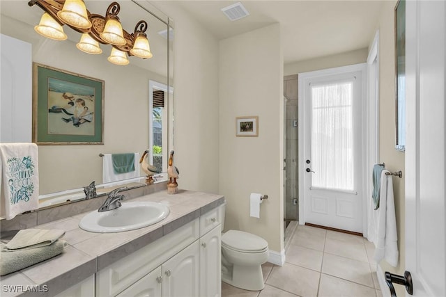 bathroom featuring a healthy amount of sunlight, a shower with door, tile patterned flooring, and vanity