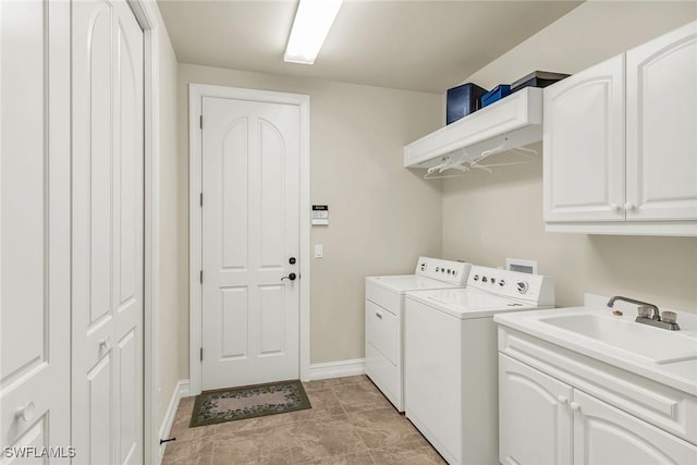 laundry room with washing machine and dryer, cabinets, and sink