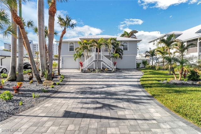 7842 Buccaneer Dr, Fort Myers Beach, FL 33931 - view of front facade featuring a garage, a front yard, and covered porch
