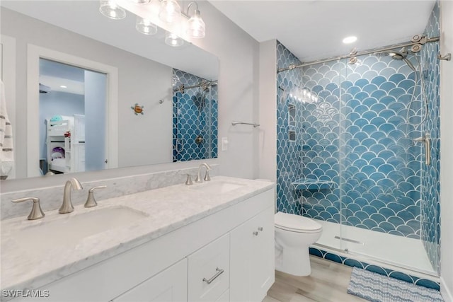 bathroom featuring vanity, toilet, and a tile shower