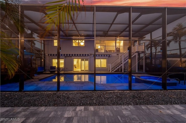 exterior space featuring a lanai, a balcony, and an in ground hot tub