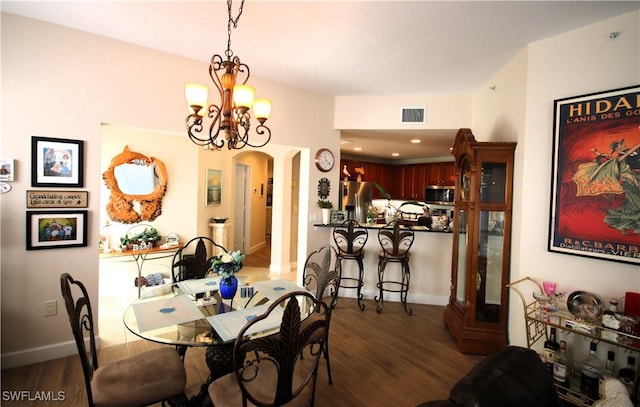 dining area with a notable chandelier and dark hardwood / wood-style flooring