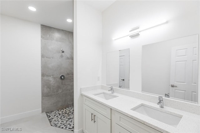 bathroom with vanity, tiled shower, and tile patterned floors