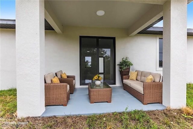 view of exterior entry with an outdoor living space and a patio