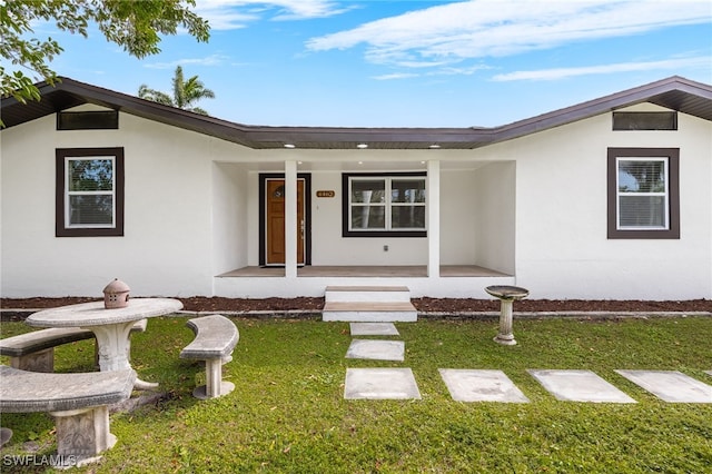 view of front of home with a porch and a front yard