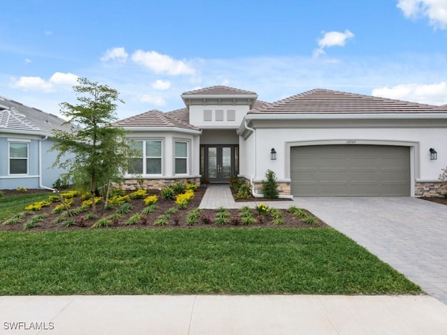 view of front of property with a garage, a front yard, and french doors