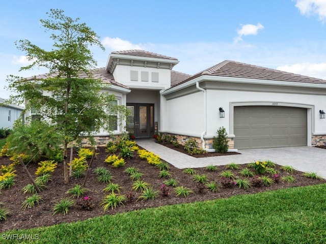 15745 Cortina St, Naples, FL 34114 - view of front of home with french doors, a tile roof, decorative driveway, a garage, and stucco siding