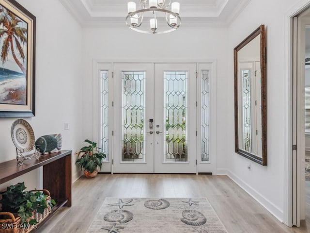 entryway with crown molding, an inviting chandelier, french doors, and light hardwood / wood-style flooring