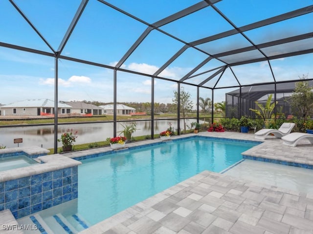 view of swimming pool with an in ground hot tub, a water view, glass enclosure, and a patio