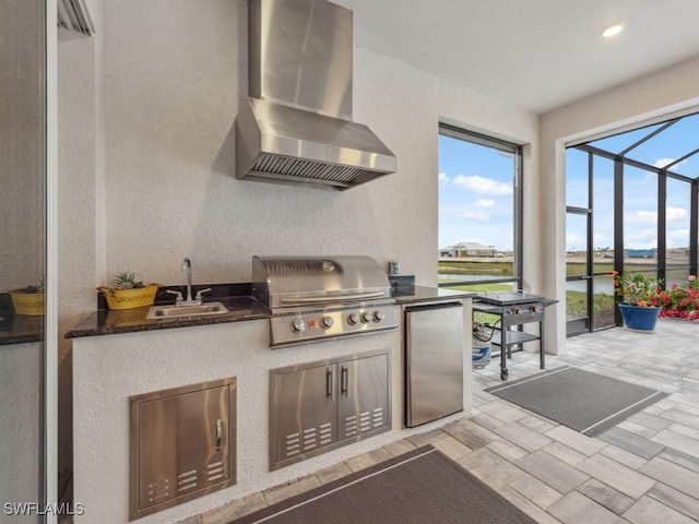 view of patio / terrace featuring a grill, exterior kitchen, sink, and glass enclosure