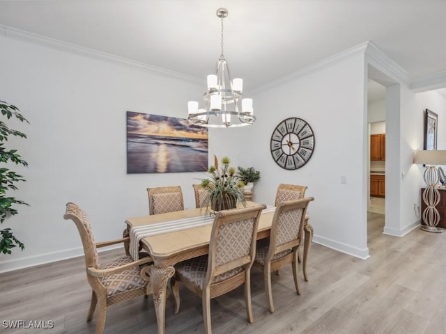 dining room with crown molding, a chandelier, and light wood-type flooring