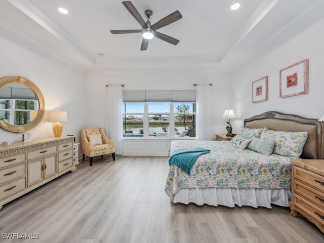 bedroom with ornamental molding, a raised ceiling, ceiling fan, and light wood-type flooring