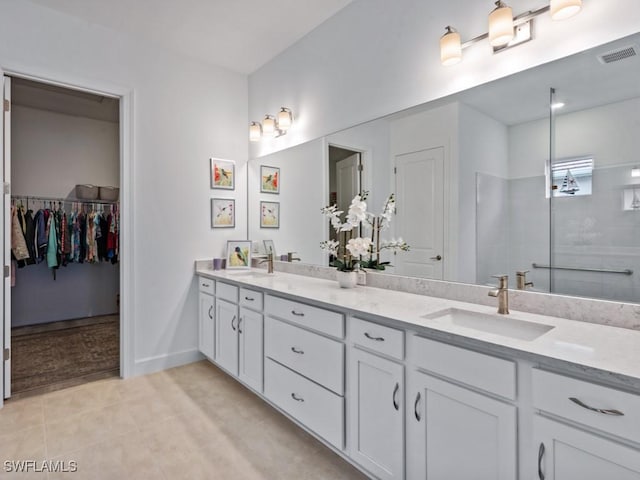 bathroom with tile patterned flooring, vanity, and walk in shower