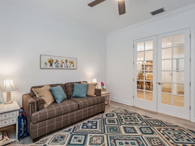 living room with hardwood / wood-style flooring, crown molding, ceiling fan, and french doors