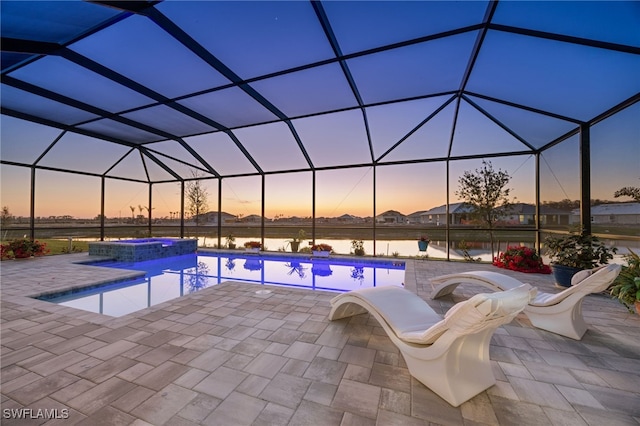 15745 Cortina St, Naples, FL 34114 - pool at dusk featuring a patio, a pool with connected hot tub, a water view, and glass enclosure