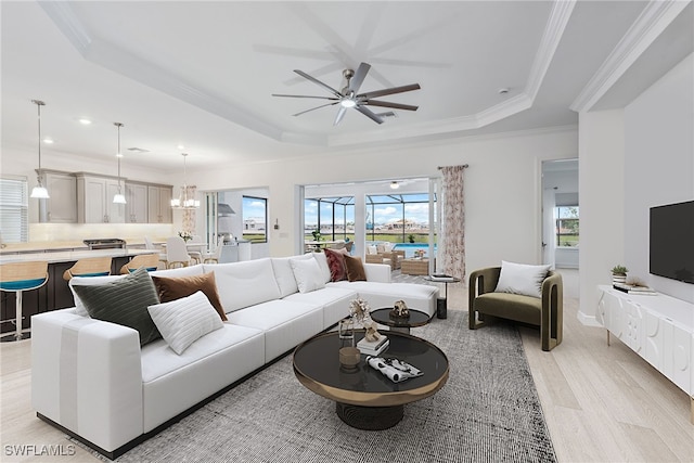 15745 Cortina St, Naples, FL 34114 - living room featuring a tray ceiling, ceiling fan, ornamental molding, light wood-style floors, and recessed lighting
