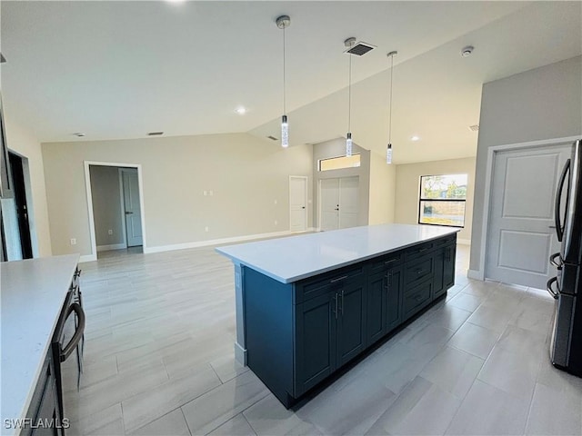 kitchen with pendant lighting, lofted ceiling, a kitchen island, and stainless steel refrigerator