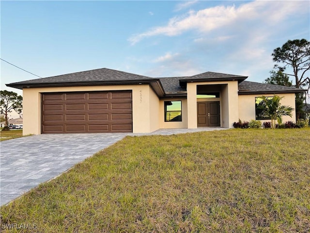 prairie-style home featuring a front lawn and a garage