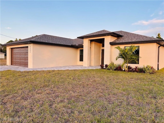 prairie-style house featuring a front lawn and a garage